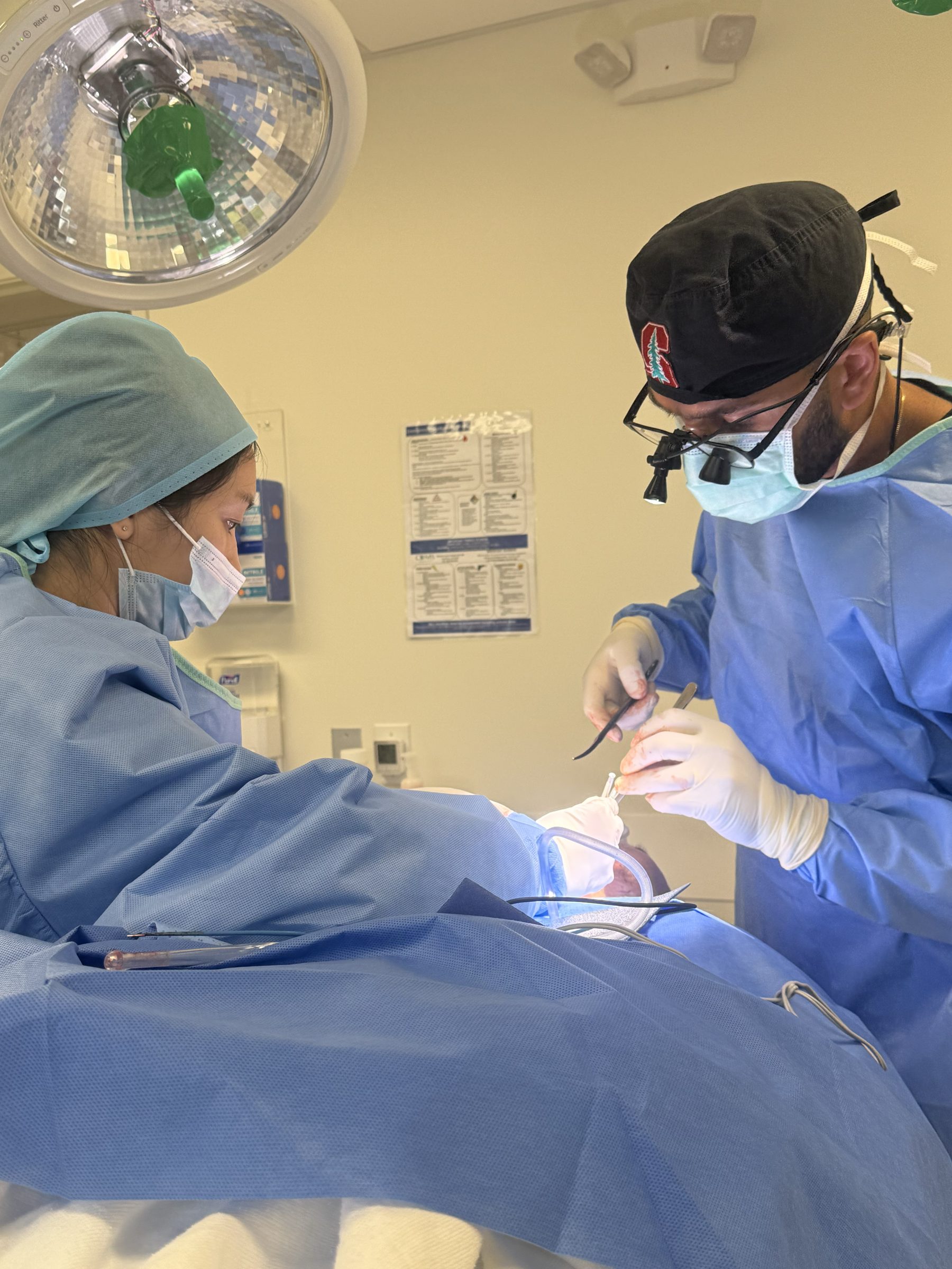 A plastic surgeon and surgical assistant performing a facial reconstruction at CDMS Surgery Center